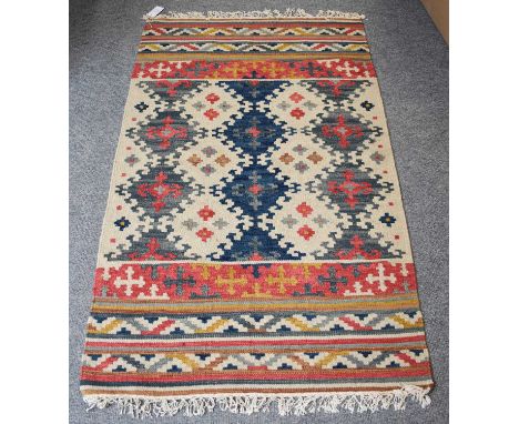 A Hamadan Rug, the crimson field with a stepped medallion framed by salmon pink borders, 196cm by 98cm, together with five ot