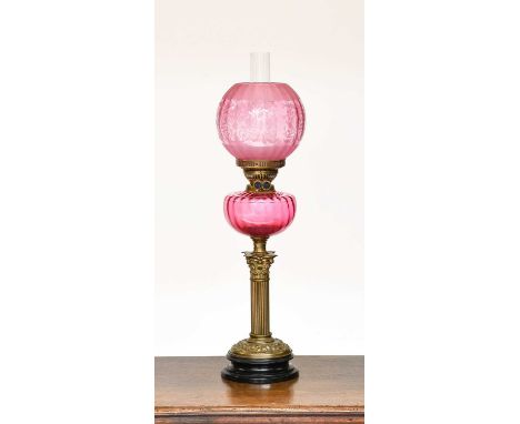 A Victorian Brass Oil Lamp, Corinthian columnar base, cranberry glass reservoir and etched cranberry shade, overall 70cm, tog