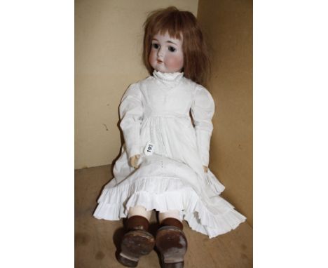 A Kammer & Reinhardt bisque head girl doll, with brown sleeping eyes, open mouth, pierced ears (one earring missing), jointed