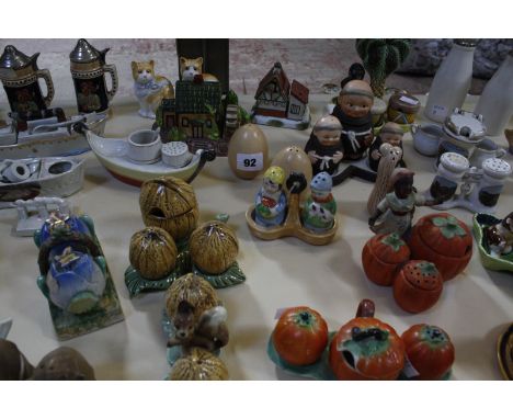 A quantity of assorted novelty ceramic condiment sets, to include Goebel monks, fish, vegetables, houses, a Caribbean bongo p