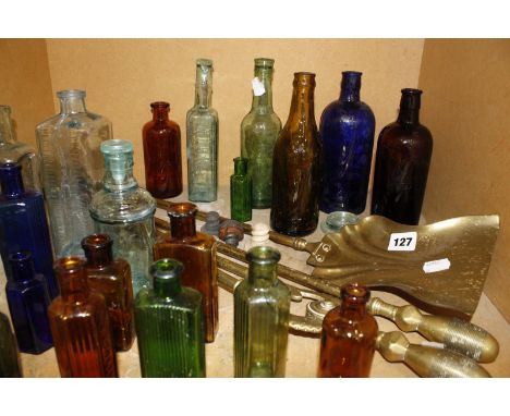 A set of 19th Century brass fire tools and a collection of old beer and pharmacy bottles