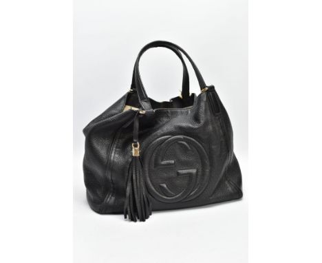 A BLACK GUCCI BAG, the soft leather with raised double G symbol to front centre, tassel attached to handle, light canvas lini