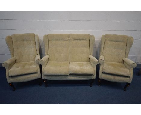 A BEIGE UPHOLSTERED WINGED BACK THREE PIECE SUITE, comprising a sofa and a pair of armchairs