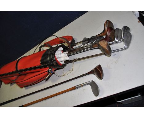 A VINTAGE GOLFBAG containing Wilson, Cochnamer, Leyland irons and A Burton, three other woods and a Hickory shafted 9 iron