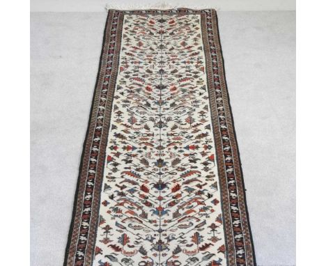 A Persian heriz runner, with floral motifs, on an ivory field, 460 x 80cmOverall condition is complete and usable. It has bee