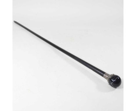 A Victorian walking cane, with an ebony shaft and silver crown, holding a polished stone ball handle, London 1884, engraved w