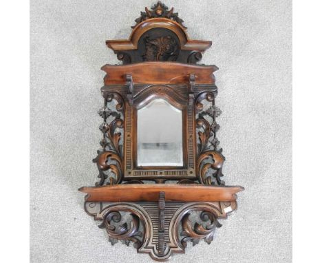 A 19th century Swiss carved softwood wall mirror, with an ornate carved surround, 80 x 43cm