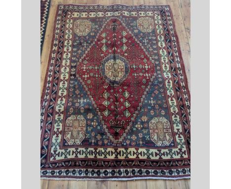 A Persian Qashgai rug, having a central diamond, on a red ground, 230 x 168cm