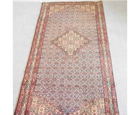 A Persian mahal runner, with a central hooked medallion, on a patterned ground, 294 x 130cm