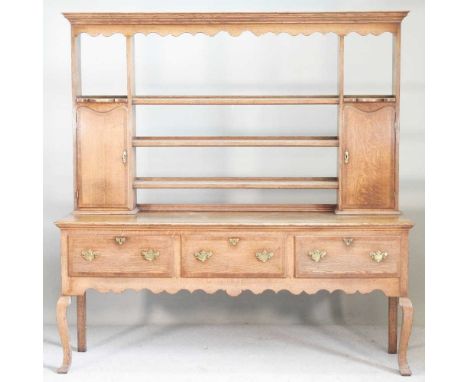 An oak and crossbanded dresser, of 18th century design, with an open plate rack and shaped apron, on cabriole legs186w x 50d 
