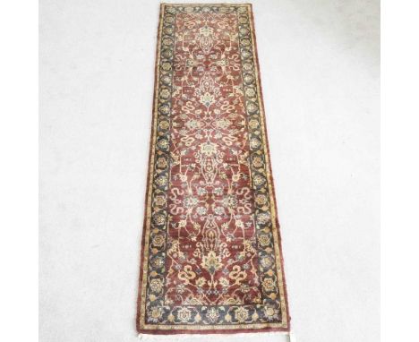 A Persian woollen runner, with all over floral design on a burgundy ground, 280 x 80cm