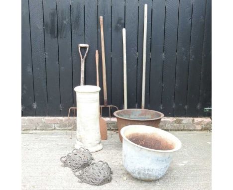 A cast metal garden pot, together with another, a metal wall planter, a chimney pot and various garden tools