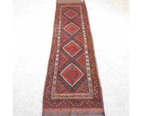 A Persian runner, with a row of four lozenges, on a red ground, 253 x 62cm