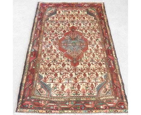 A Persian rug, having a floral field with foliate designs, on an ivory coloured ground, 150 x 95cm