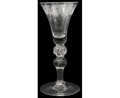 A mid 18th century engraved light baluster wine glass c.1750the bell bowl engraved with fruiting vine set on on a beaded cush