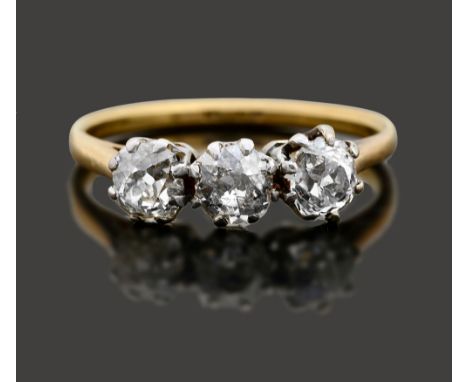 A diamond three stone ringthe cushion-shaped old brilliant-cut diamonds coronet-set to the plain tapering setting stamped '18