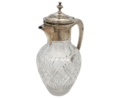 A SILVER MOUNTED GLASS CLARET JUG, tapered baluster form with faceted and cut glass decoration, the simplistic silver collar 