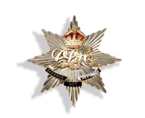 A WWII 'DEFENCE NOT DEFIANCE' BADGE star shaped with applied gold and enamel lettering, scroll and crown. Marked silver, 18ct