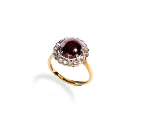 GARNET AND ROSE CUT DIAMOND RING set with a large claw set garnet cabochon surrounded by a halo of small rose-cut diamonds. S