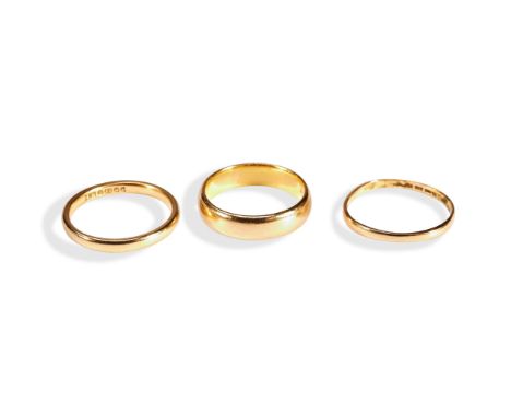 THREE 22CT GOLD BANDS a thin straight band. Marked 22ct, London, 1934. Ring size N Weight 1.4gms a thin rounded band. Marked,