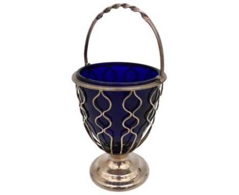 A SILVER WIREWORK SUGAR BOWL, with blue glass liner, rope twist swing handle, raised on a spreading foot, bears the mark of H