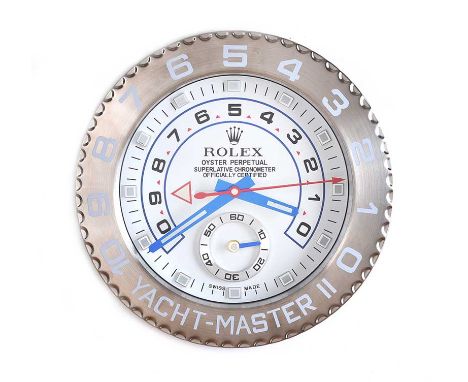 CIRCULAR STAINLESS STEEL WALL CLOCK. ROLEX YACHT MASTER WITH DIAL OF 10 INCHES AND BATTERY MOVEMENT.DIAMETER: 13 INCHES.IN GO