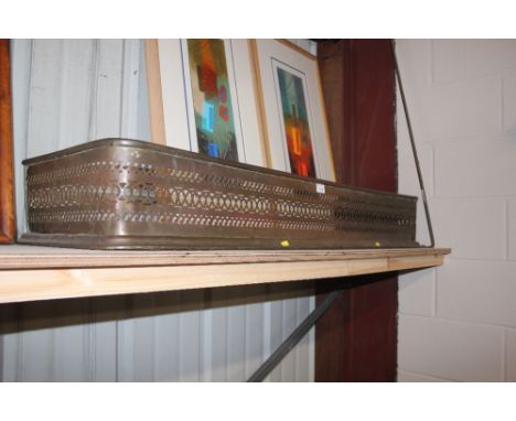 A pierced brass fire fender