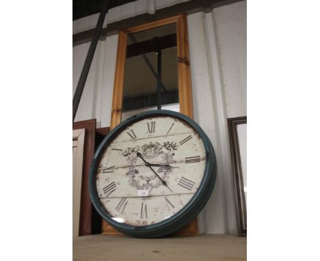 A large modern wall clock and a pine framed oblong mirror