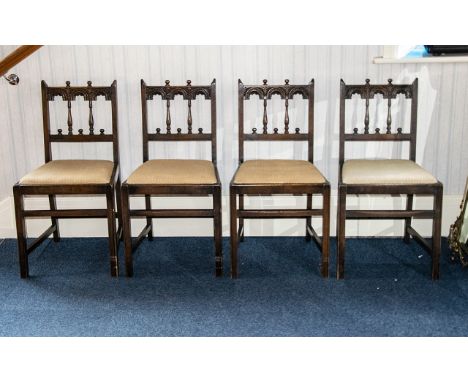 A Set Of Four Jacobean Style Dining Chairs carved and spindle back with drop-in seat, square cross-stretelers, Ercol label to