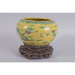 A 19TH CENTURY CHINESE SANCAI PORCELAIN DRAGON BOWL ON HARDWOOD STAND, bowl with carved character
