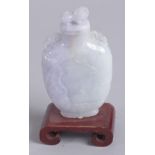 A 20TH CENTURY CHINESE CARVED JADEITE SNUFF BOTTLE, mounted to a wooden stand, 8cm high.