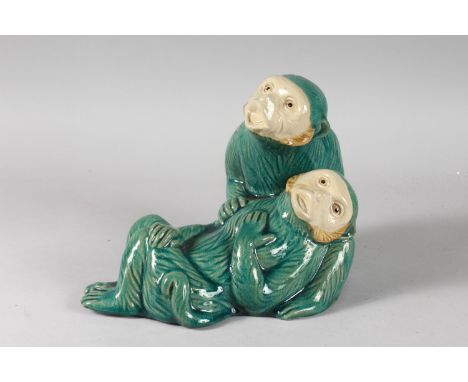A LARGE CHINESE TURQUOISE GLAZED POTTERY GROUP OF TWO MONKEYS, the base with impressed mark, 27cm long, 20cm high.