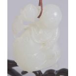 A 19TH CENTURY CHINESE CARVED WHITE JADE PENDANT; figure holding a carp, on a hanging wooden
