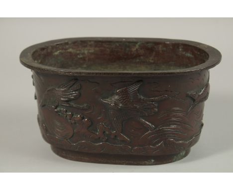 A BRONZE OVAL FORM JARDINIERE, with relief decoration of cranes, the base with character mark, 22cm wide.