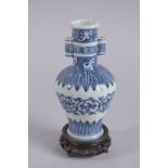A CHINESE BLUE AND WHITE PORCELAIN TWIN HANDLE VASE ON HARDWOOD STAND, the base with six-character
