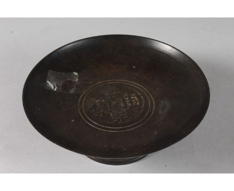 A CHINESE BRONZE FOOTED CIRCULAR DISH, with central characters, 18cm diameter.