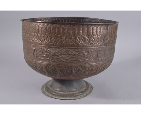 A LARGE LATE QAJAR EMBOSSED AND CHASED FOOTED COPPER BOWL, with a band of calligraphy and paisley designs, 26cm high, 34cm wi