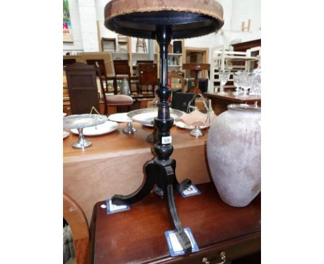 An ebonised tripod table