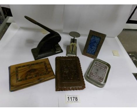 A folder of pressed flowers, a note wallet, a photo frame, an advertising paperweight, a press and letter scales