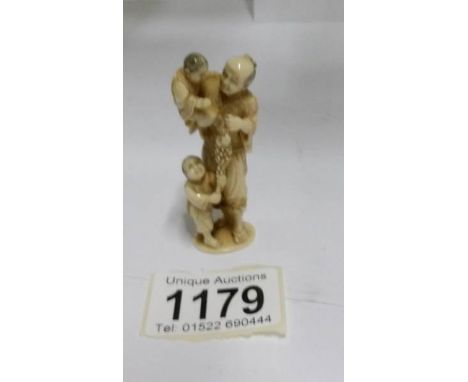 An signed antique ivory netsuke of an Chinese gentleman with 2 children