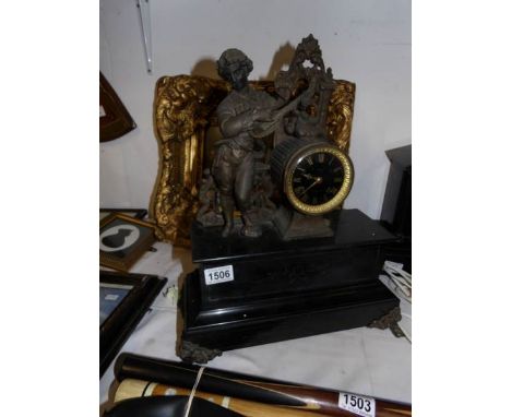 A French black marble mantel clock with spelter minstrell atop