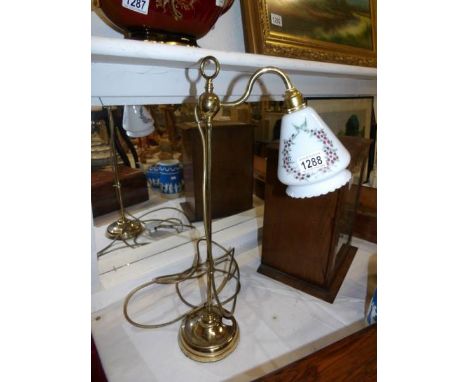 An old brass reading lamp with hand painted shade