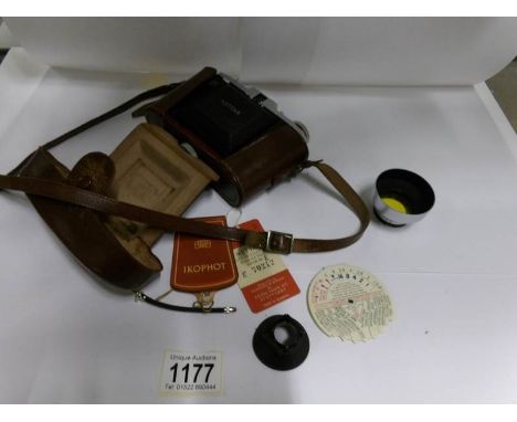 A Zeiss Ikon camera & case, an exposure calculator and an Actina lens hood