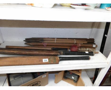 A set of wickets and vintage cricket bats