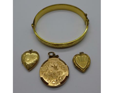 A rolled gold bangle and three lockets, marked 9ct back and front