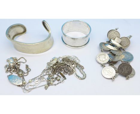 A silver napkin ring, a silver coin bracelet, a silver bangle and silver chains, 115g