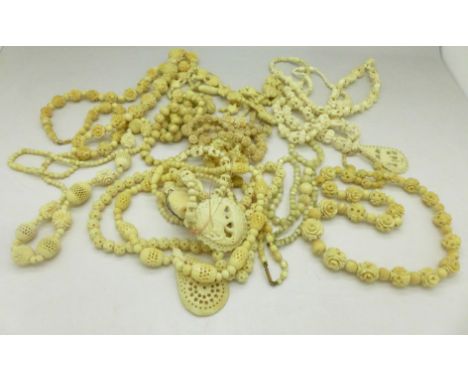 A collection of necklaces including carved bone and one mother of pearl