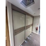 A Sliding 3 door Fitted Wardrobe Display with 3 Hanging Rails and Central Section of Hanging Unit;