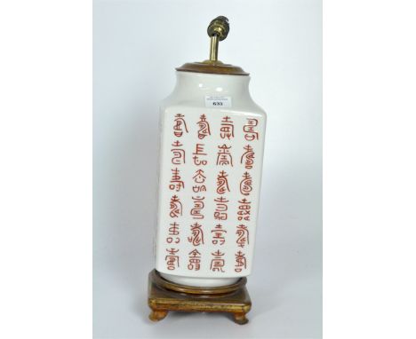 A contemporary oriental lamp, the ceramic body painted with symbols, mounted on a circular wooden base, height 48cm
