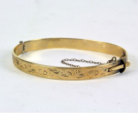 A 9ct gold bangle (having metal core) engraved with foliate decoration, 12.5g